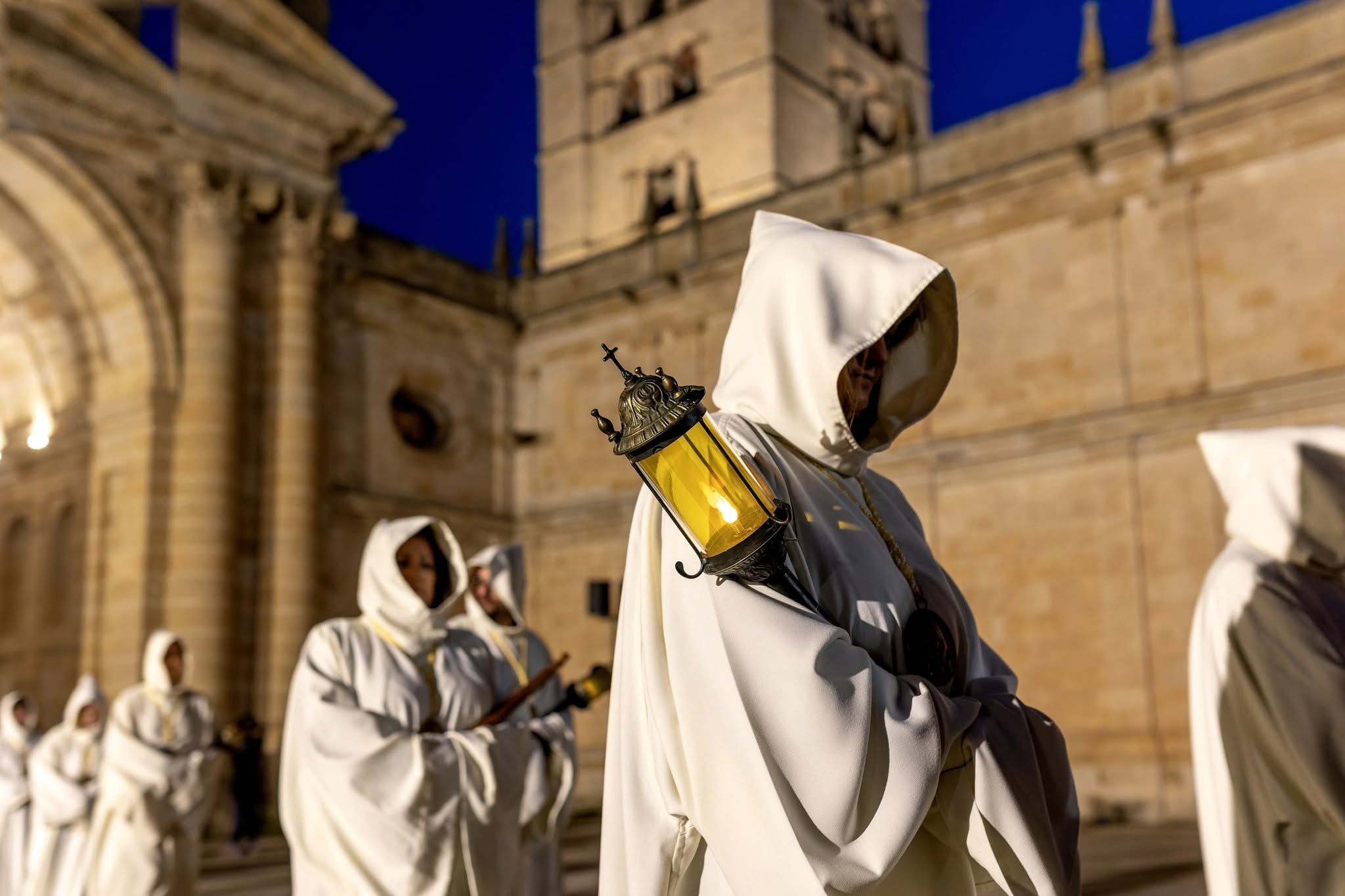Hermano portando el farol artesanal a la salida de la Catedral, al anochecer